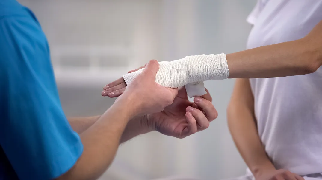 Orthopedist applying wrist elastic wrap on female patient hand. if you've been injured due to another's negligence, our Kansas City personal injury lawyers can help you. 