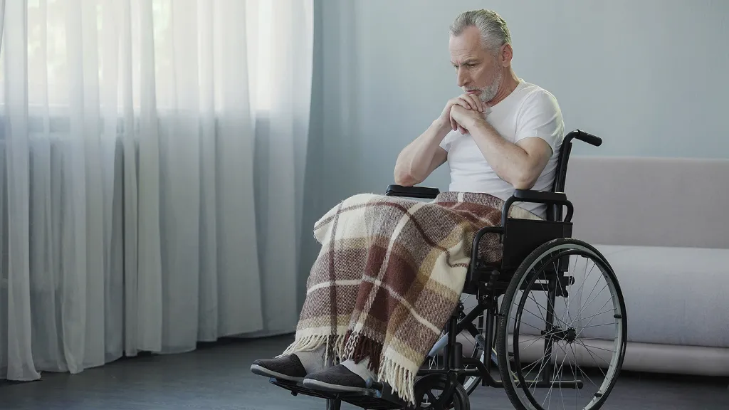 Elderly man in wheelchair staring blankly at floor. If you suspect your loved one is being abused or neglected in a nursing home, our nursing home abuse lawyers are here to help.