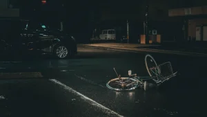 A dark night with a van and a bike laying on the ground. If you are a cyclist who has experienced a collision with a car or truck and has suffered injuries our Kansas City bike accident lawyer provides decades of experience and can help obtain compensation.