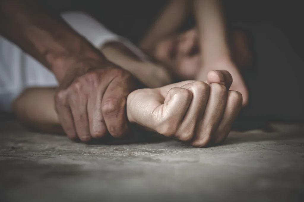 Close up of hands and someone being held down due to sexual abuse.
