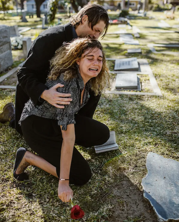 Woman crying over grave of a loved one who died of a wrongful death. 