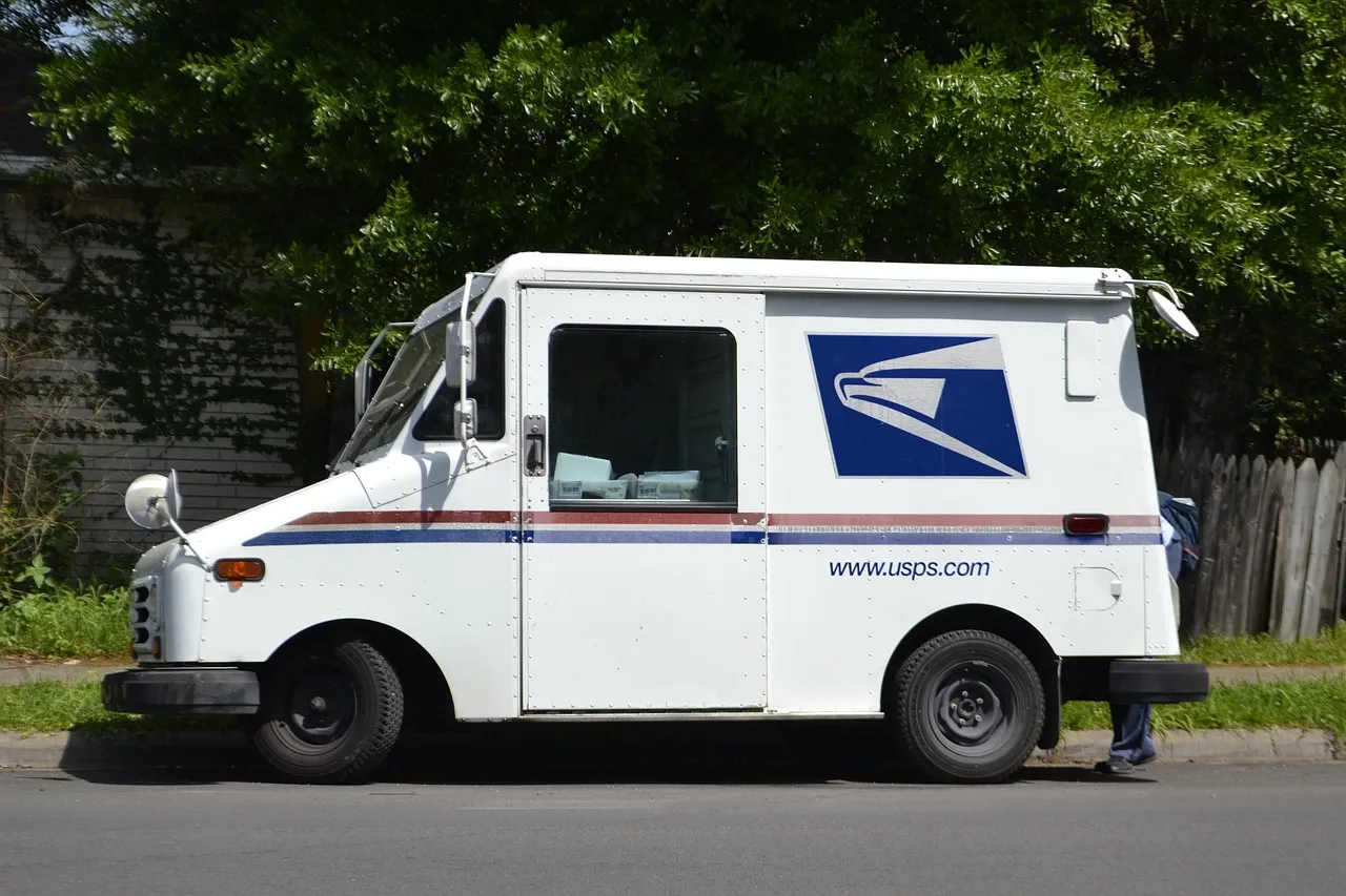 A USPS truck parked on the side of the street.