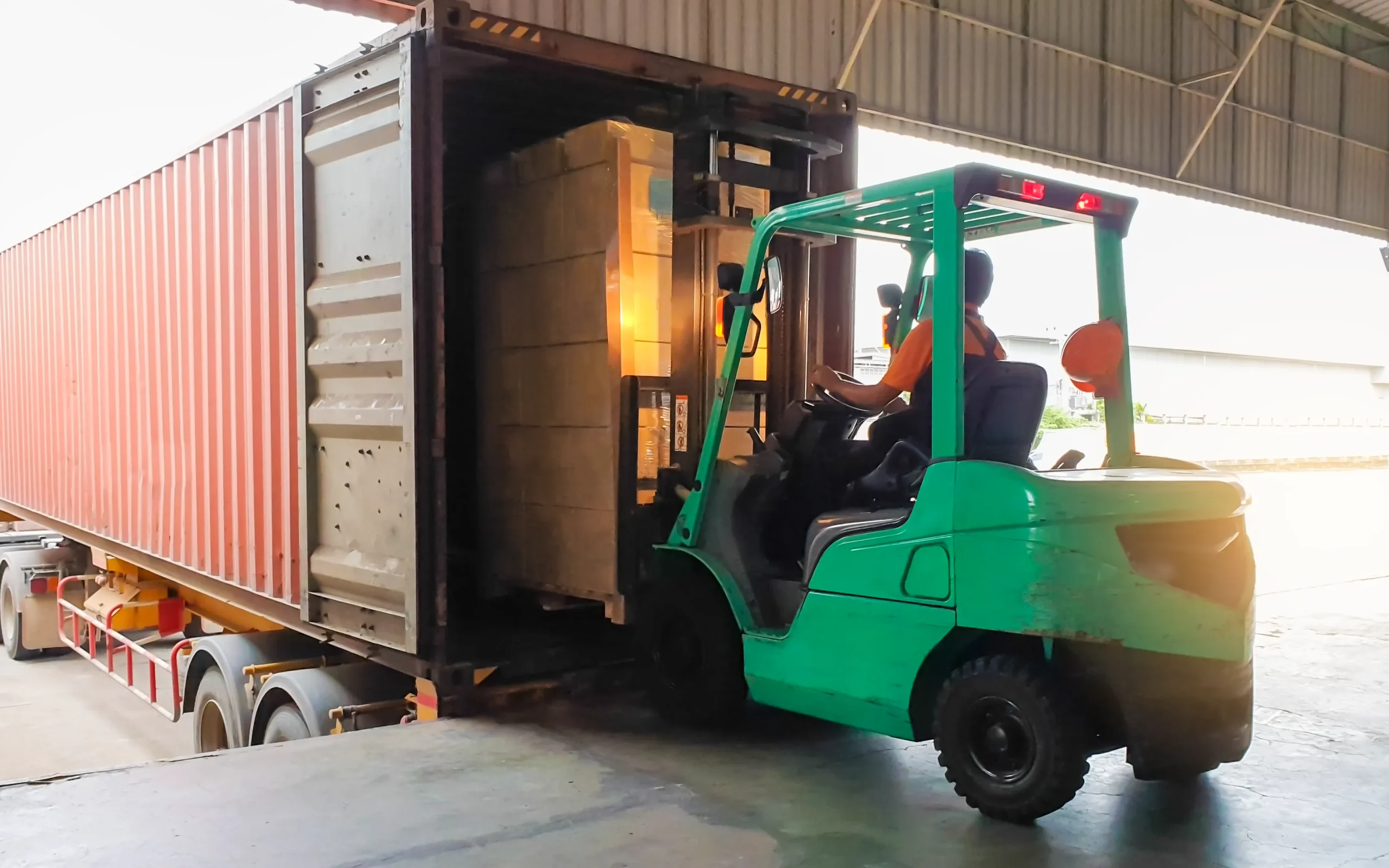 A forklift loading cargo in a commercial truck.