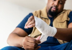 A man wrapping his hand after an injury.