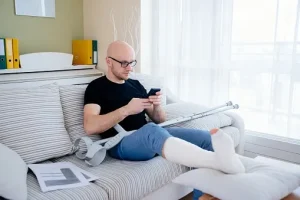 A person with a broken foot sitting on the couch.