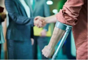 Man in crutches shaking hands with someone else.