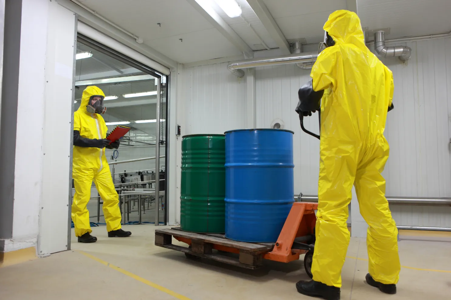 Workers in safety clothing while transporting hazardous materials.