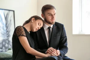 A couple grieving at a funeral service.