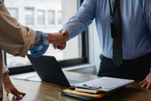 A lawyer shaking hands with a new client in an office setting.