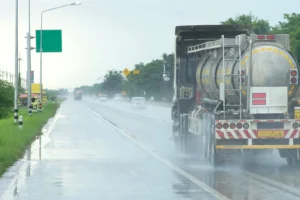 A truck driving on the highway in the rain.