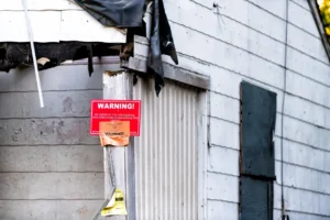A broken down building with a warning sign. 